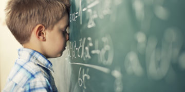 Little boy in math class overwhelmed by the math formula.