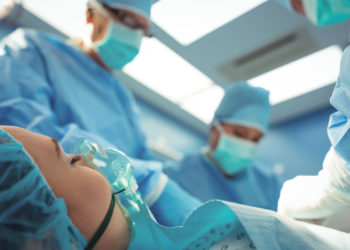 Team of surgeons performing operation in operation theater at hospital