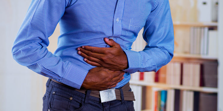 Man feeling strong pain in his stomach, makes pressure with both hands.