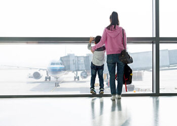 Asian mother and son waiting for flight at the airport.