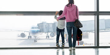 Asian mother and son waiting for flight at the airport.