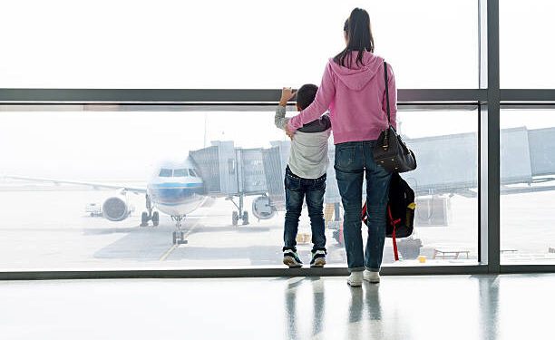 Asian mother and son waiting for flight at the airport.