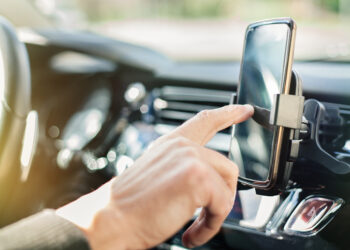 Close up of a man using smart phone while driving