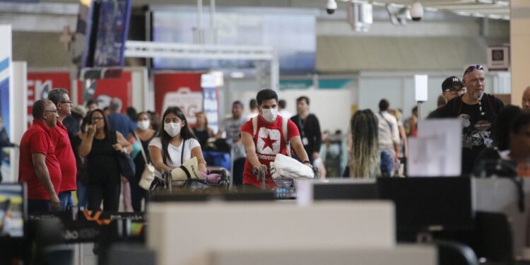 Passageiros e funcionários circulam vestindo máscaras contra o novo coronavírus (Covid-19) no Aeroporto Internacional Tom Jobim- Rio Galeão