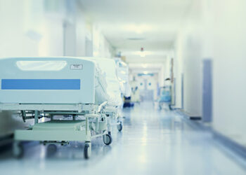 Where healing happens. Shot of a hospital bed in an empty corridor of a modern hospital.