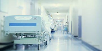 Where healing happens. Shot of a hospital bed in an empty corridor of a modern hospital.